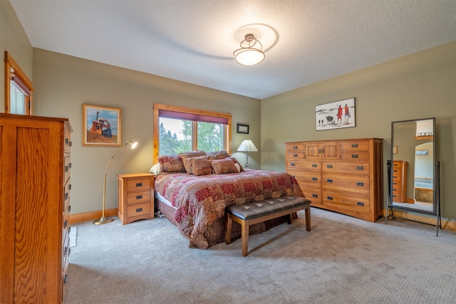 bedroom with light carpet and a textured ceiling