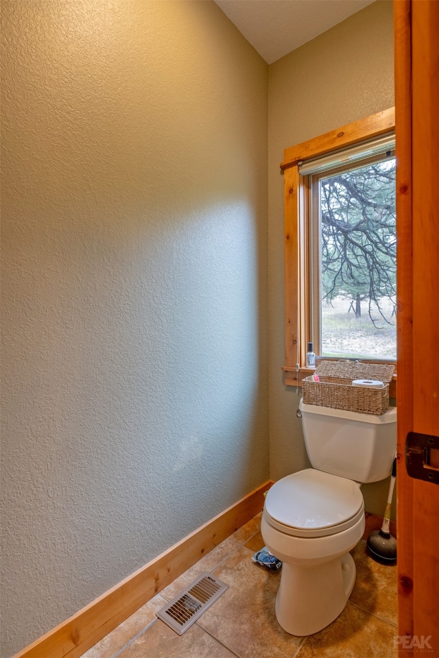 bathroom with toilet and tile patterned flooring