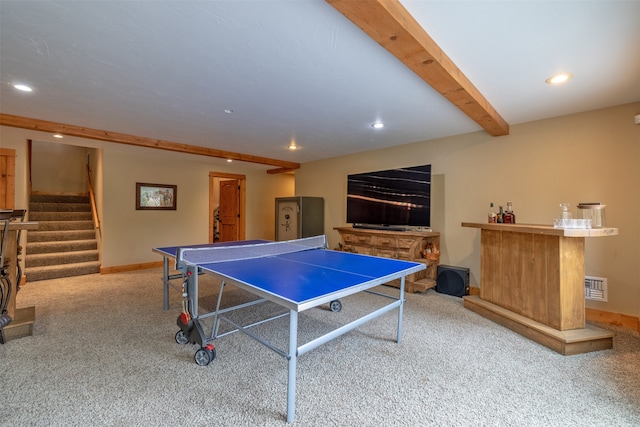 recreation room featuring indoor bar, beamed ceiling, and light colored carpet