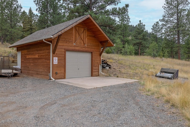 214 Solomon Mountain Rd, Clancy, MT 59634 - detached garage featuring gravel driveway and a forest view