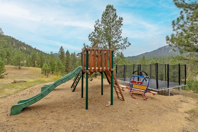 view of playground featuring a trampoline and a mountain view