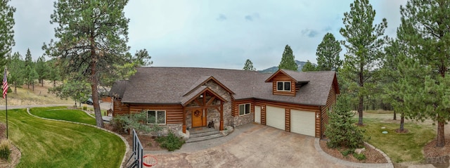 214 Solomon Mountain Rd, Clancy, MT 59634 - cabin featuring driveway, stone siding, a front yard, and a garage
