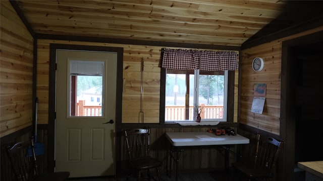 interior space featuring vaulted ceiling, wood ceiling, a healthy amount of sunlight, and wood walls