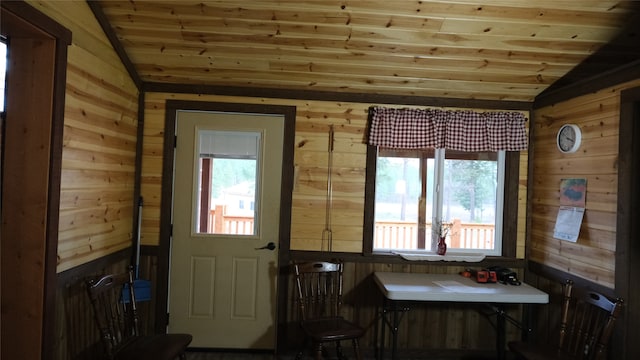 dining room with wooden ceiling, lofted ceiling, and wooden walls