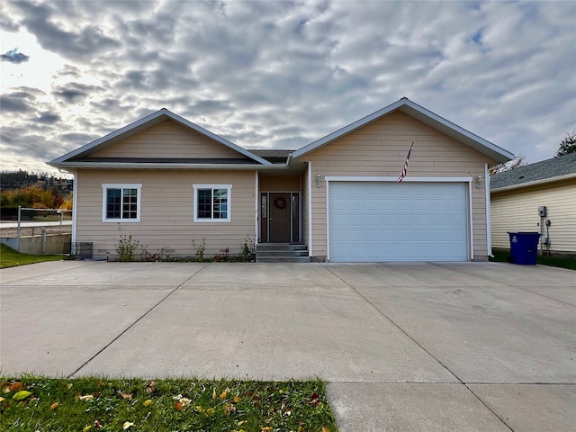 single story home with cooling unit and a garage