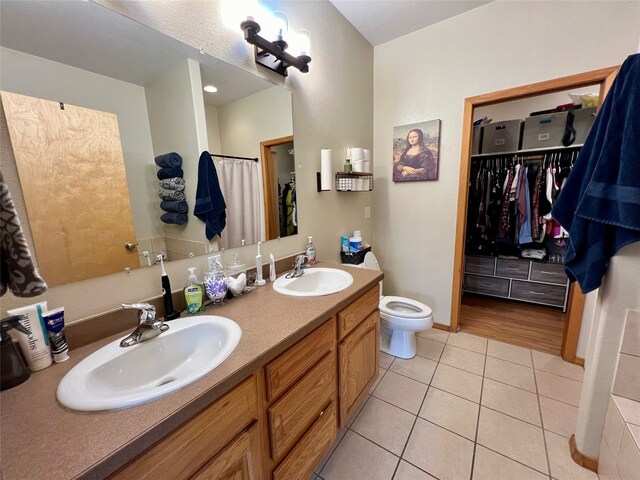 bathroom with toilet, vanity, and tile patterned floors