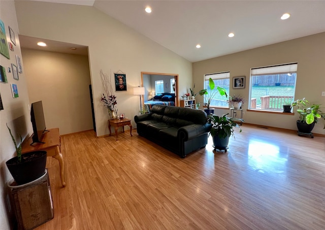 living room featuring light hardwood / wood-style floors and high vaulted ceiling