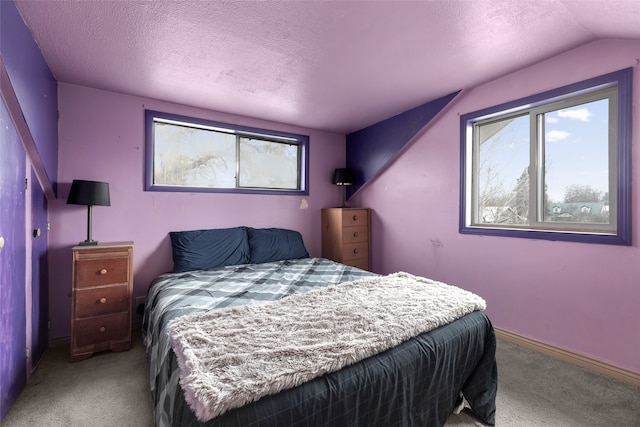 bedroom featuring vaulted ceiling, light carpet, and a textured ceiling