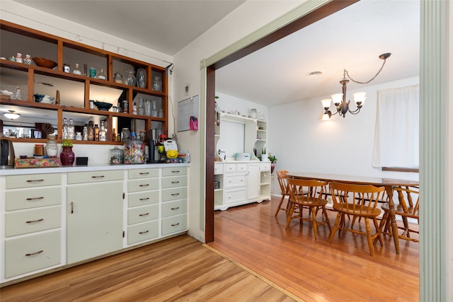 dining area with light hardwood / wood-style flooring and an inviting chandelier