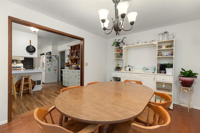 dining area featuring an inviting chandelier and light hardwood / wood-style flooring