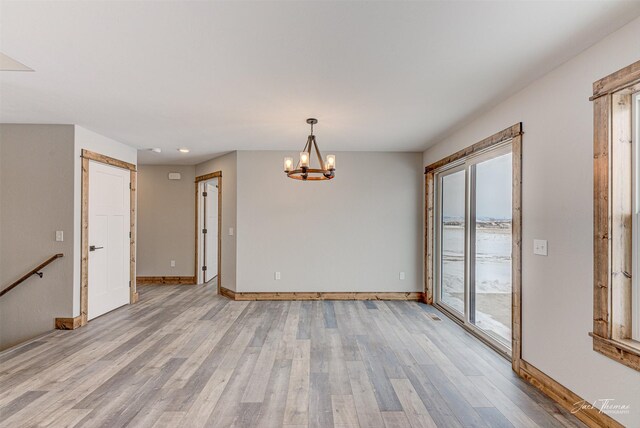 kitchen with pendant lighting, light stone countertops, an island with sink, light hardwood / wood-style floors, and a breakfast bar area