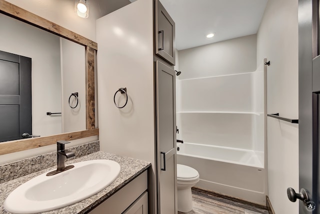 full bathroom featuring shower / bathtub combination, hardwood / wood-style floors, toilet, and vanity