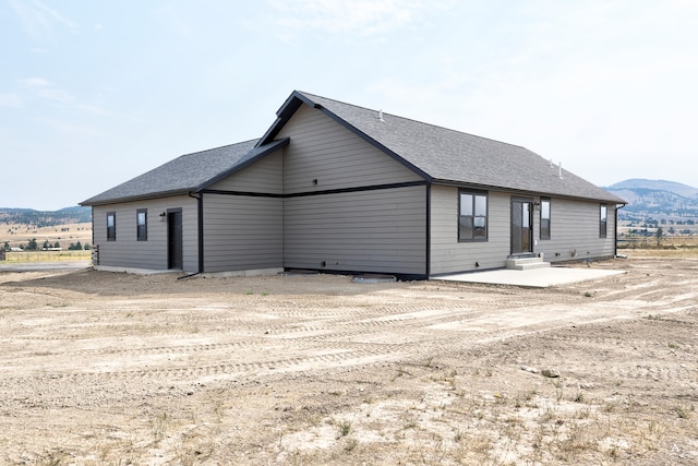 rear view of property featuring a mountain view and a patio area