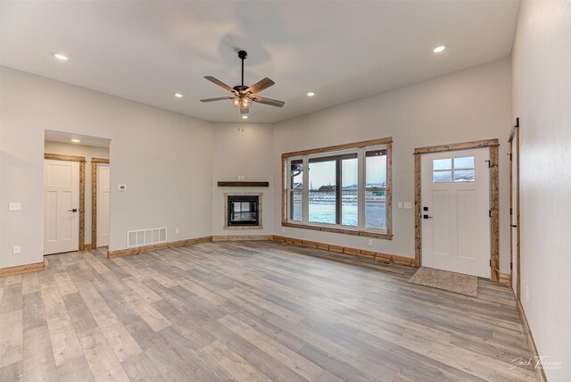 unfurnished living room with ceiling fan and light wood-type flooring