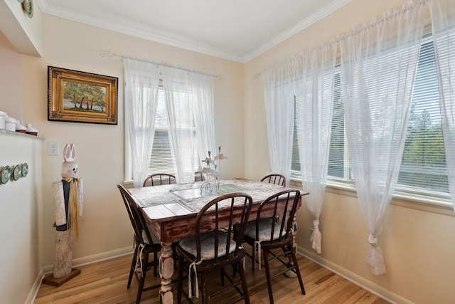 dining area featuring hardwood / wood-style flooring and ornamental molding