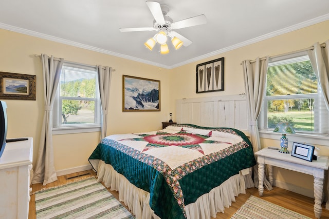 bedroom featuring crown molding, light hardwood / wood-style floors, and ceiling fan