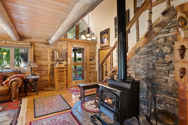 living room with beam ceiling, hardwood / wood-style flooring, a wood stove, and wood ceiling