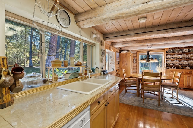 kitchen with sink, wood ceiling, tile counters, beam ceiling, and light hardwood / wood-style flooring