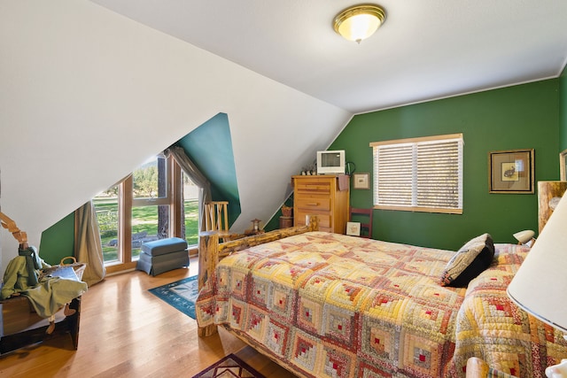 bedroom featuring lofted ceiling and light hardwood / wood-style floors