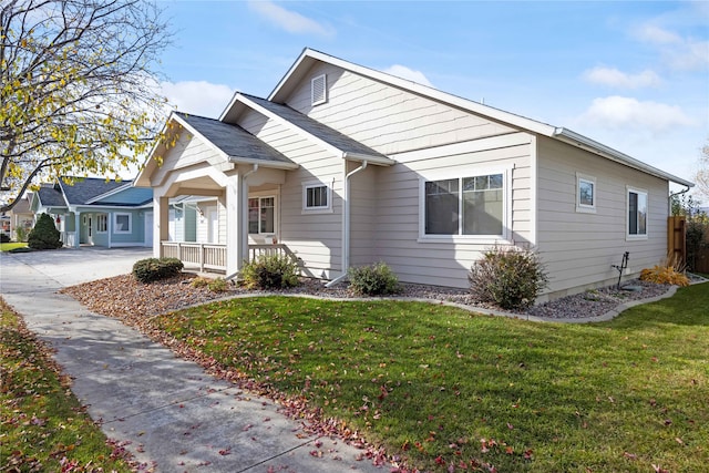 view of front of home with covered porch and a front lawn