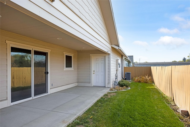 doorway to property with a patio, central AC, and a lawn