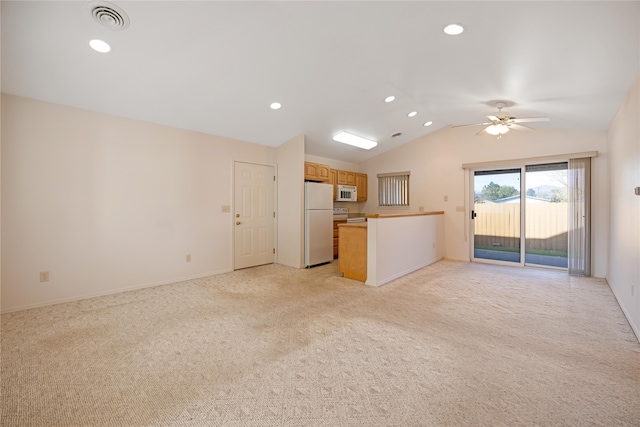 unfurnished living room with vaulted ceiling, light carpet, and ceiling fan