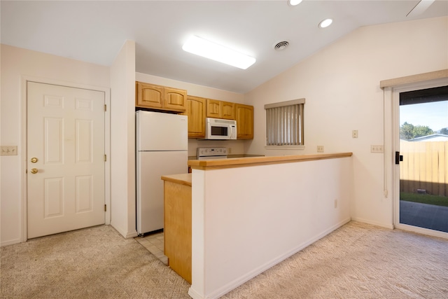 kitchen featuring white appliances, lofted ceiling, kitchen peninsula, and light colored carpet