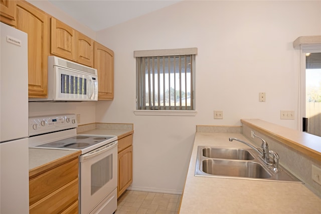 kitchen featuring lofted ceiling, sink, light brown cabinets, and white appliances