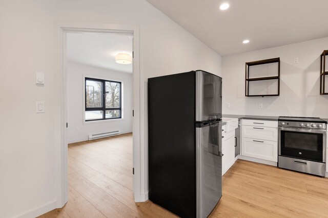 kitchen with light hardwood / wood-style floors, white cabinets, stainless steel appliances, and a baseboard radiator