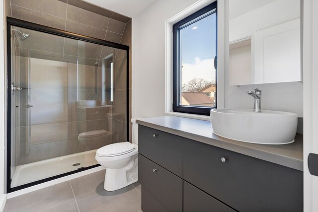 bathroom featuring vanity, tile patterned floors, toilet, and walk in shower