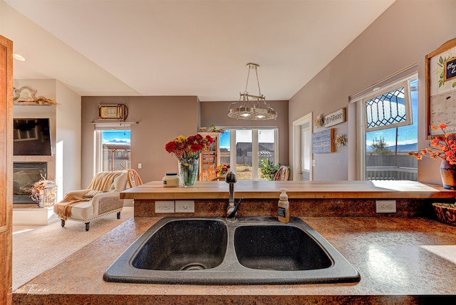 kitchen featuring sink, pendant lighting, and carpet floors