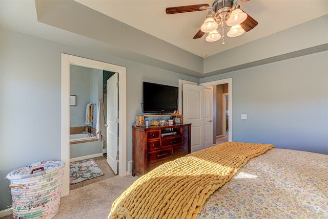 bedroom with ceiling fan, light carpet, and ensuite bathroom