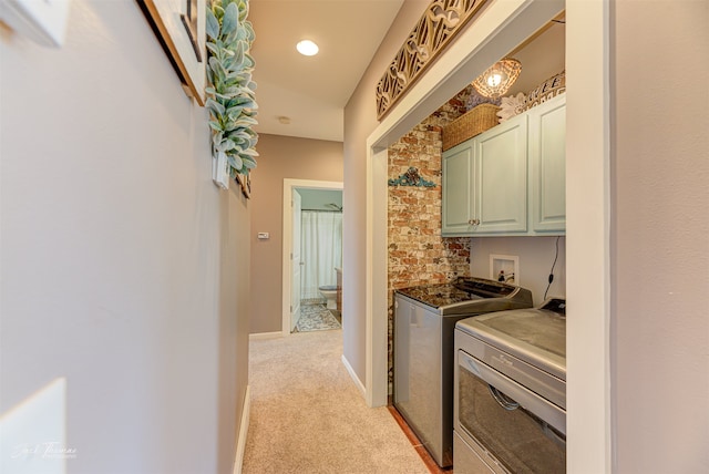 laundry area with cabinets, light carpet, and washer and clothes dryer