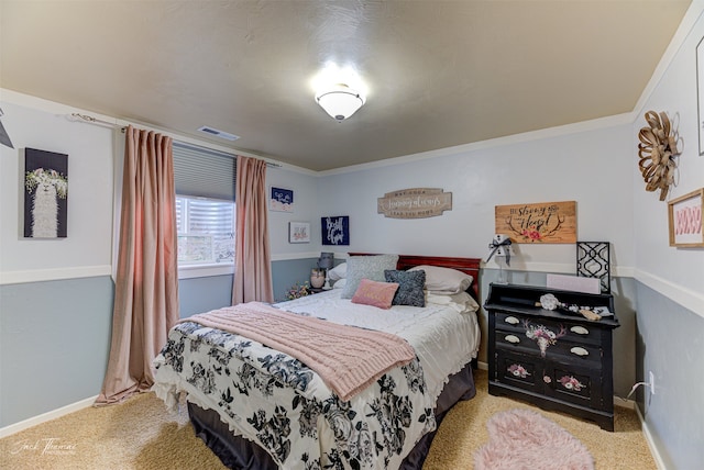 bedroom with ornamental molding and light colored carpet