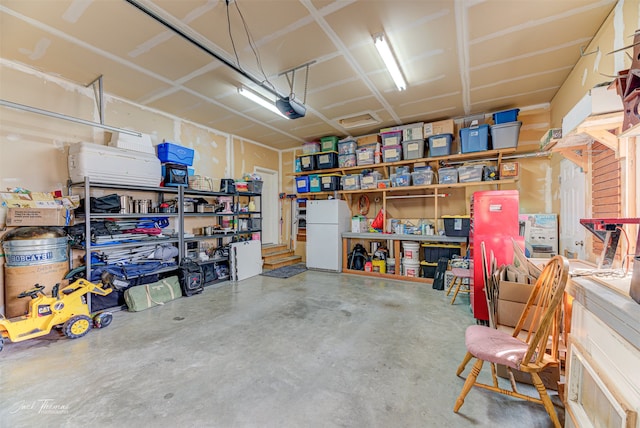 garage featuring a garage door opener and white fridge