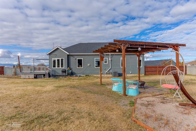 back of property with a yard, central air condition unit, and a pergola