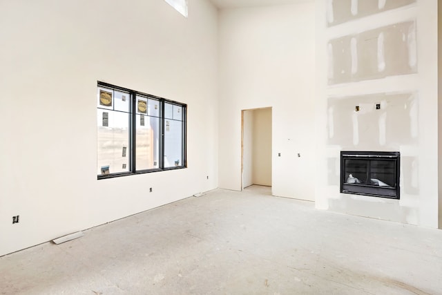 unfurnished living room featuring a high ceiling