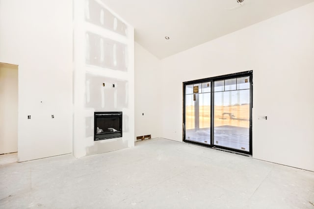 unfurnished living room with high vaulted ceiling