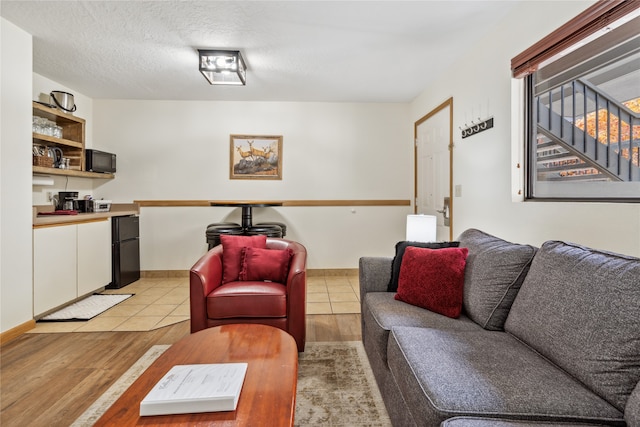 living room with a textured ceiling and light hardwood / wood-style floors