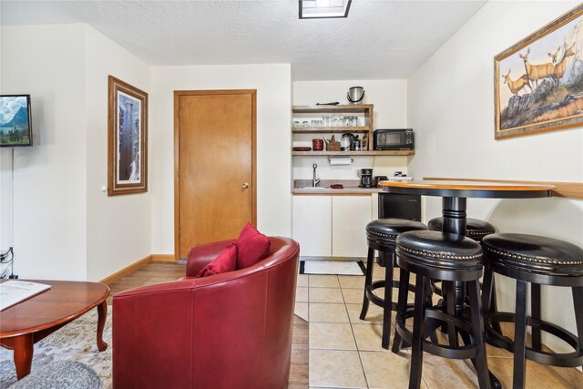 180 Vista Ln Unit 137, Bigfork, MT 59911 - indoor bar featuring black microwave, a textured ceiling, and light tile patterned floors