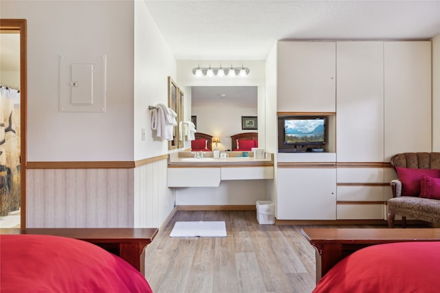 bedroom with light hardwood / wood-style floors and electric panel