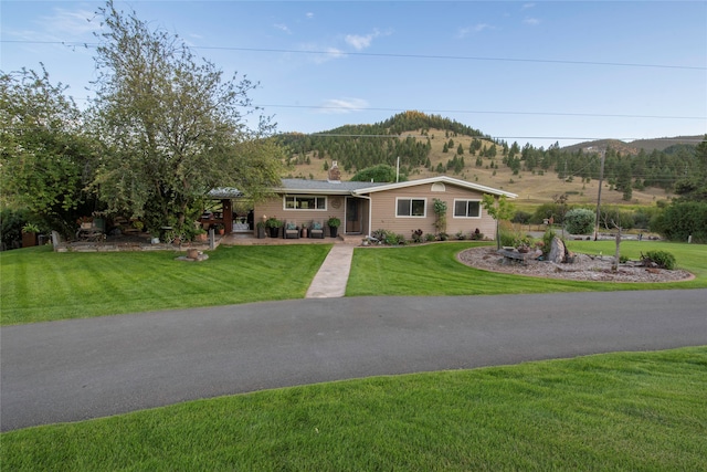 ranch-style house featuring a mountain view and a front lawn