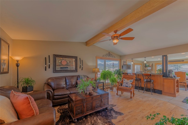 living room featuring lofted ceiling with beams, light wood-type flooring, and ceiling fan