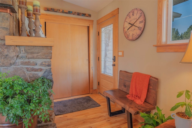 foyer featuring a healthy amount of sunlight, vaulted ceiling, and hardwood / wood-style floors