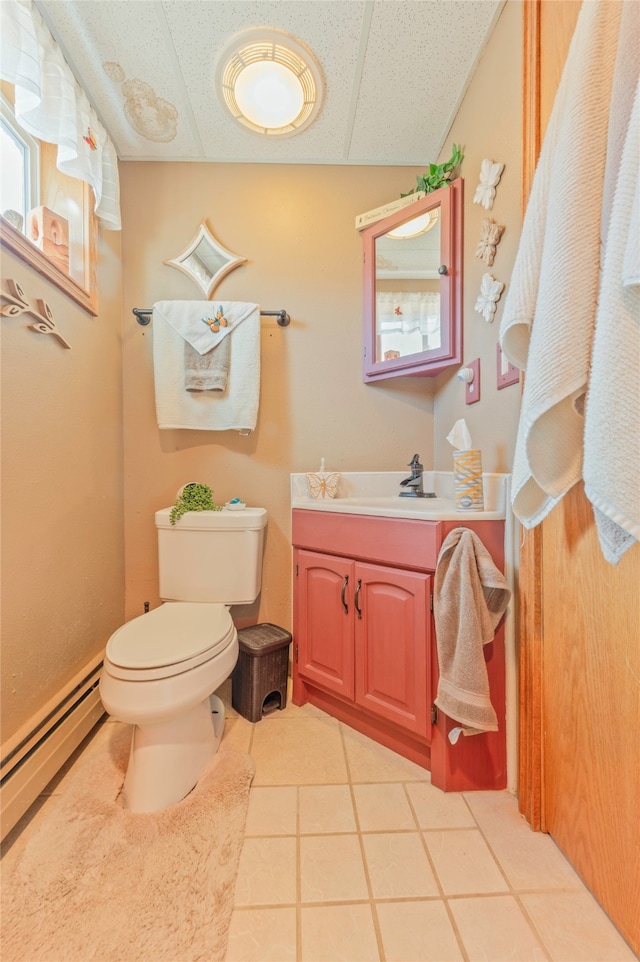 bathroom featuring a baseboard radiator, toilet, vanity, a drop ceiling, and tile patterned flooring