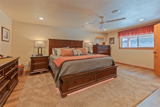 bedroom featuring light hardwood / wood-style floors, a textured ceiling, and ceiling fan