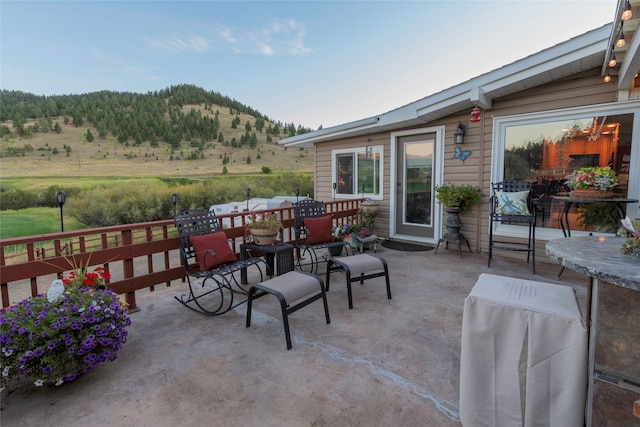 view of patio / terrace featuring a mountain view and a rural view