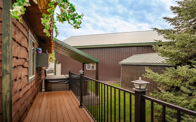 wooden terrace with a hot tub and a yard