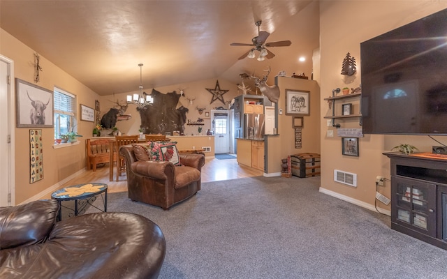 living room featuring lofted ceiling, light colored carpet, ceiling fan with notable chandelier, and a wealth of natural light