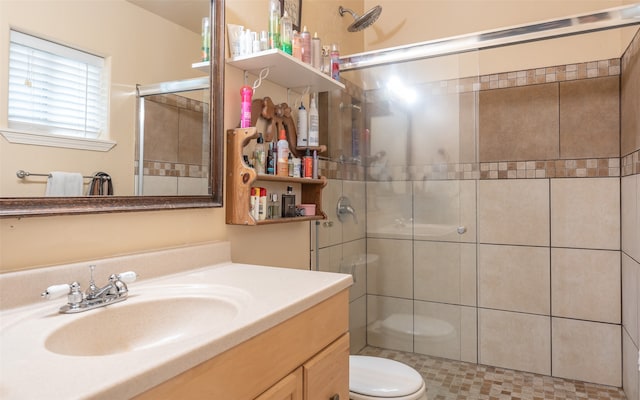 bathroom featuring vanity, toilet, and a shower with shower door